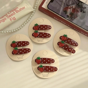 Sweet strawberry polka dot hair clips set on beige card with elegant aesthetic background