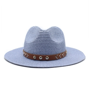 Macro detail of sky blue straw cowboy hat featuring brown leather band and silver metal studs
