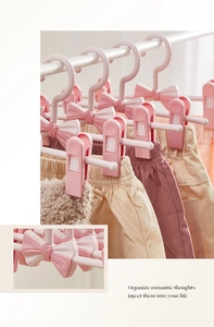 Pink bow-shaped children's clothes hanger with adjustable non-slip clips and matte finish