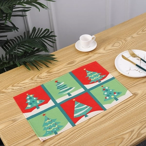 Festive red and green Christmas tree grid placemat shown on a wooden dining table