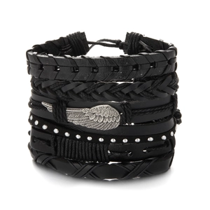 Detailed close-up of layered black leather bracelet with silver metal wing charm
