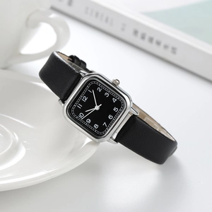 Detail of square quartz watch with black leather strap and elegant numeric dial face