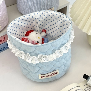 Close-up of light blue heart quilted fabric basket with white lace trim and polka dot lining