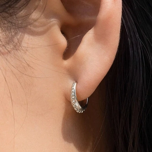 Close-up of S925 sterling silver hoop earring with small beads on a model's ear