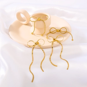 18K gold plated bowknot long tassel earrings and bracelet set on white silk background