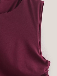 Detailed view of burgundy sleeveless dress featuring pleated texture and soft fabric