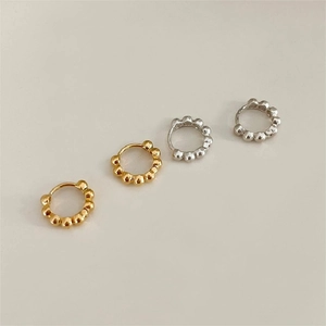 Detailed view of sterling silver beaded hoop earrings in gold and silver finishes