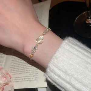 Detail of gold-plated clover bracelet featuring cat-eye stone and sparkling zircons