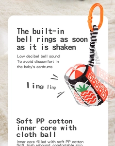 Detail showing the plush baby rattle ball with high-contrast patterns and a soft hanging loop