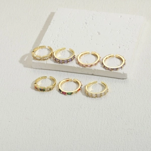 Macro shot of 14K gold plated baguette zircon rings displayed on white stone texture