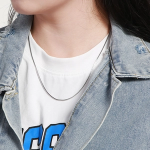 Silver snake chain necklace worn by model showing smooth metallic texture and shine