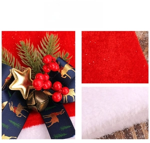 Detail of red plush Christmas hat with golden star bell and reindeer ribbon trim
