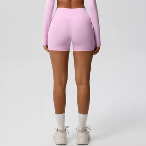 Detail view of pink high-waist fitness shorts showing moisture-wicking fabric and slim fit