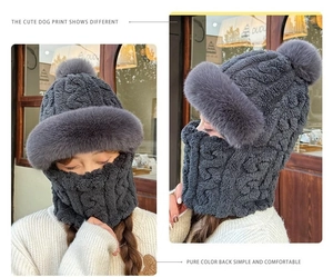 Detail of grey cable-knit winter hood with thick faux fur trim and fluffy pom-pom