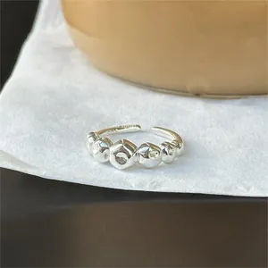 Detailed view of an irregular 925 sterling silver geometric open ring on white paper