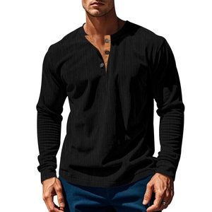 Detail of men's corduroy Henley shirt showing black fabric and brown contrast placket