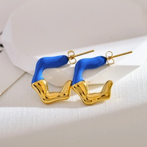Detail of irregular C-shaped gold earrings with royal blue enamel and polished finish