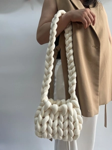 Model wearing a chunky knit shoulder bag in cream white showing size and texture