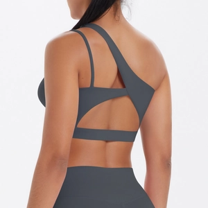 Detail view of dark grey asymmetric backless sports bra and matching yoga leggings