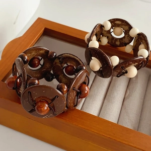 Macro detail of elastic ethnic bracelets with coconut shell discs and colorful wooden beads