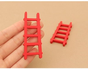 Detailed close-up of a hand holding a miniature red wooden ladder for dollhouse decoration