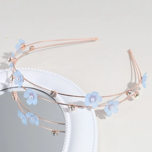 Close-up of double-layer rose gold headband with light blue flowers and shiny rhinestones