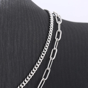 Close-up of stacked silver titanium steel Cuban and paperclip chains with OT buckle