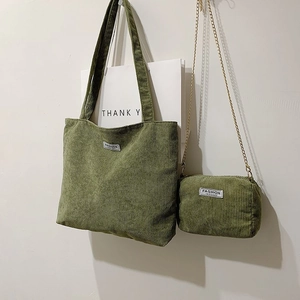 Detail of vintage green corduroy tote bag and matching chain purse with woven labels