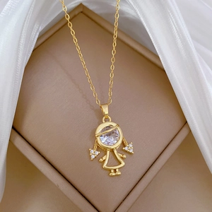 Detailed view of a gold girl pendant with sparkling crystals in a beige jewelry box