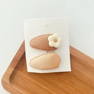 Brown flower hair clips for girls set on a wooden tray with a minimalist aesthetic style
