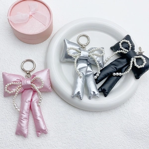 Handmade pearl bow keychains in pink, silver, and black satin fabric for bags and cars