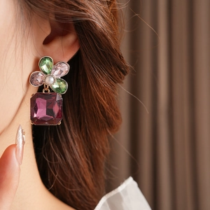 Detail view of vintage square drop earrings with colorful crystals and center pearl inlay