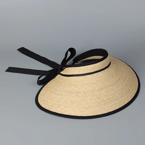 Detailed macro view of the woven raffia texture and the elegant black ribbon bow at the back