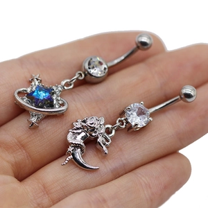 Détail macro de piercings de nombril argentés avec étoile bleue et croissant de lune