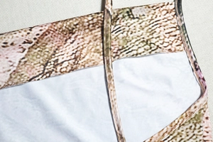 Detailed macro view of snake print pattern and stitching on a sleeveless dress strap