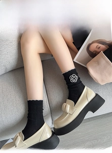Close-up of black Lolita mid-tube socks featuring a pearl camellia flower ornament