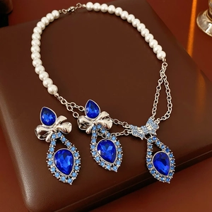 Detail of vintage bow pendant jewelry set with blue teardrop crystals and pearls