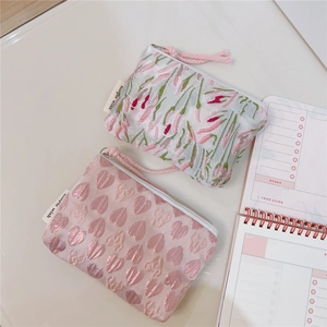 Close-up of pink heart and tulip jacquard fabric mini pouches with white zippers