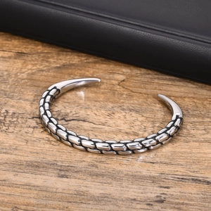 Vintage silver stainless steel open cuff bracelet with twisted chain texture on wood