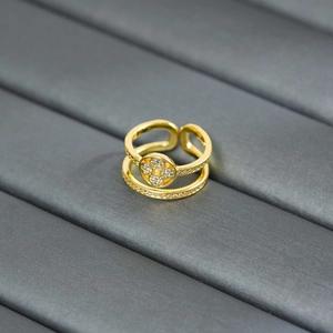 Macro view of gold double-layer ring with zircon four-leaf clover detail on velvet