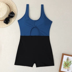 Flat lay of a cutout color-block one-piece swimsuit with boyshorts and summer accessories