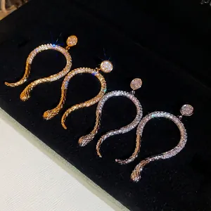 14k gold and silver snake earrings with pave zircons on black velvet jewelry box