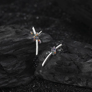 Close-up of S925 sterling silver rope studs with colorful zircon crystals on black rock