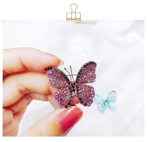 Close-up of purple and pink rhinestone butterfly brooch with gold metallic detailing