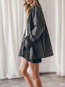 Detail of oversized dark grey washed denim shirt jacket with metal buttons and texture