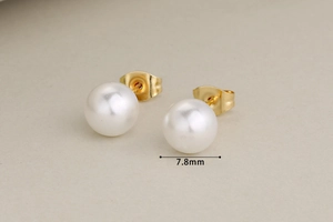 Macro shot of 7.8mm white pearl stud earrings with minimalist gold metal backings