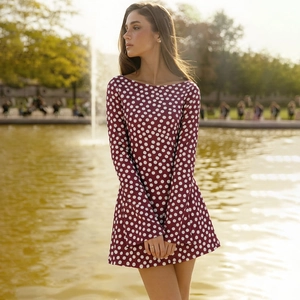 Close-up of a long-sleeved dark red polka dot mini dress with a slim-fit retro design