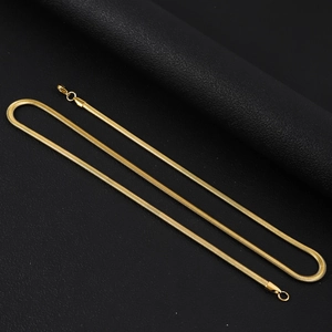 Chaîne serpent plate dorée avec fermoir mousqueton sur fond de cuir noir élégant