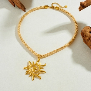 Collier pendentif soleil en acier inoxydable doré avec chaîne torsadée sur décor bois