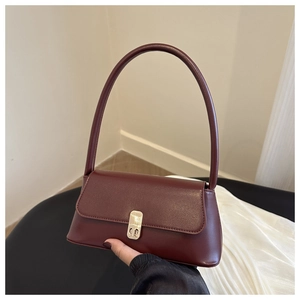 Close-up of wine red PU leather shoulder bag featuring magnetic metal buckle closure